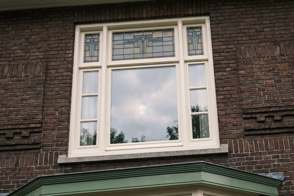 Wit geschilderd houten kozijn met roedeverdeling in een jaren-30-woning